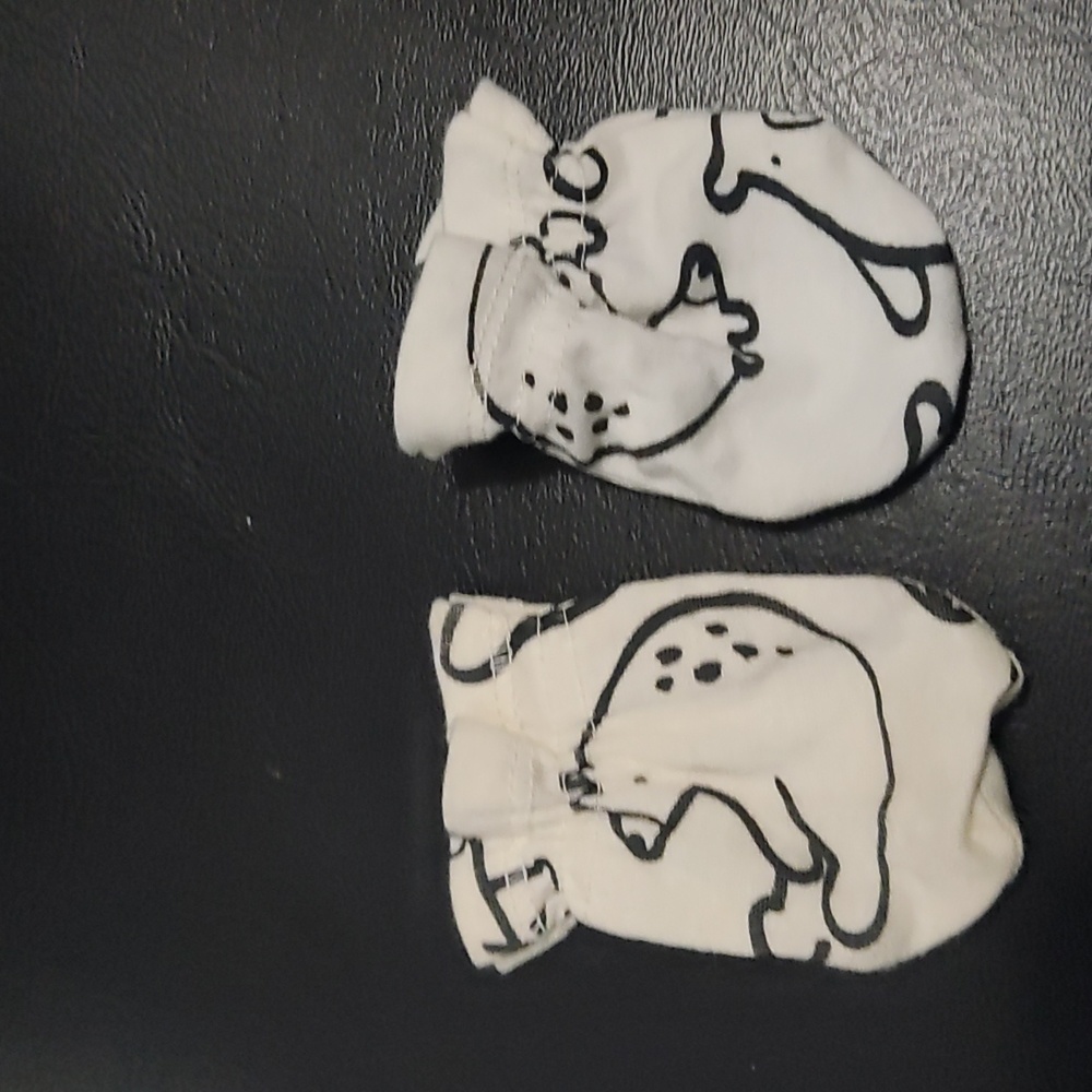 White infant mittens with black outline of an animal.